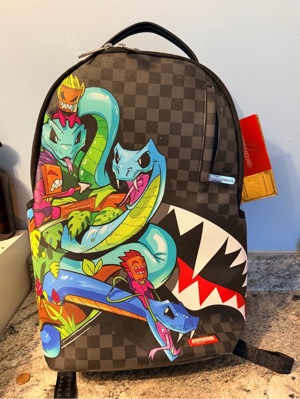 Sprayground Black Checkerboard Backpack with Colorful Snake Graphic